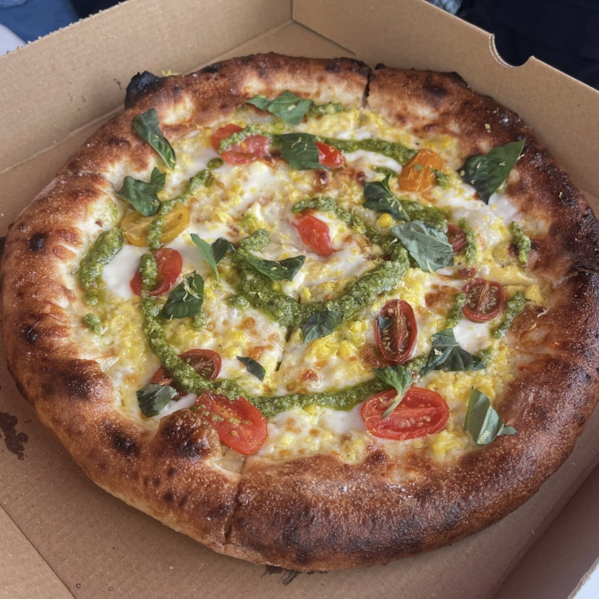 Sweet Corn Crème pizza with pesto, marinated tomatoes, mozzarella and basil at Burnt Mouth Pizza Orlando